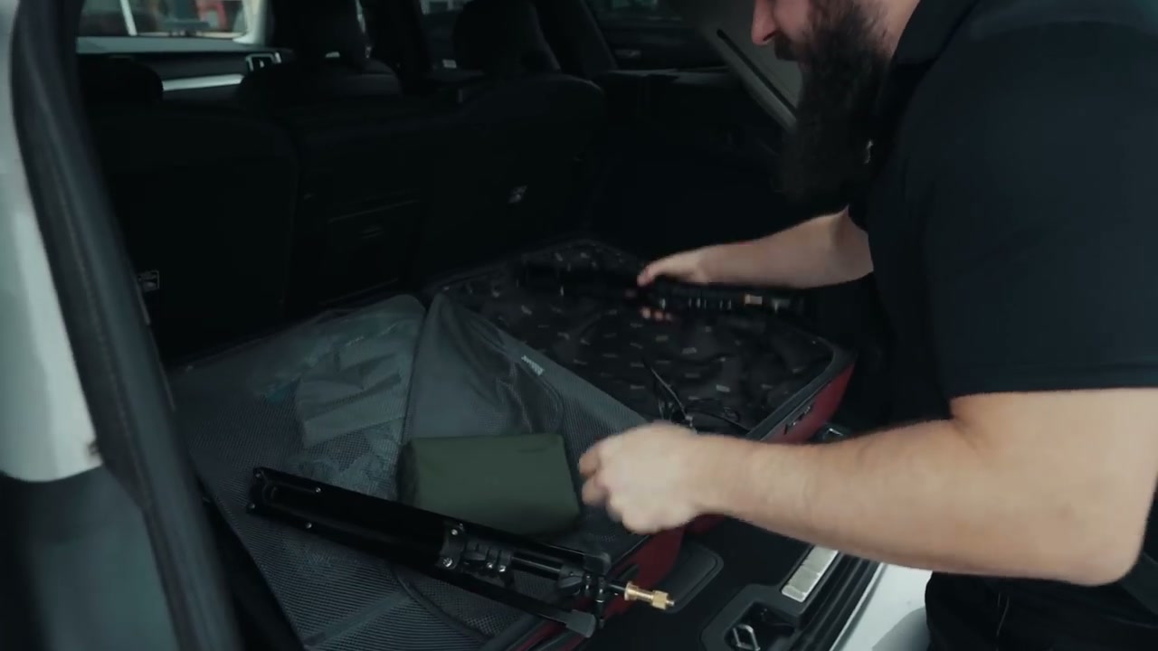 An open suitcase packed with light stands and small LED lights used as a travel lighting kit