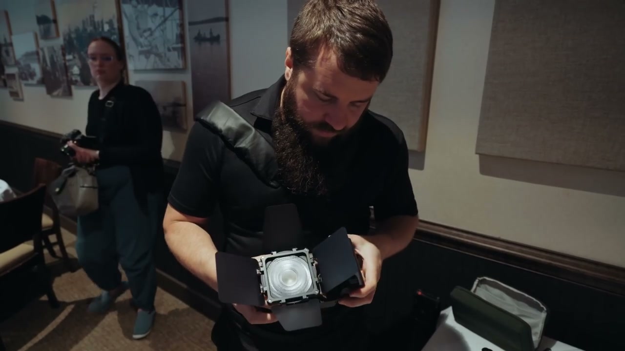 A compact LED panel light fitting inside a small padded camera bag