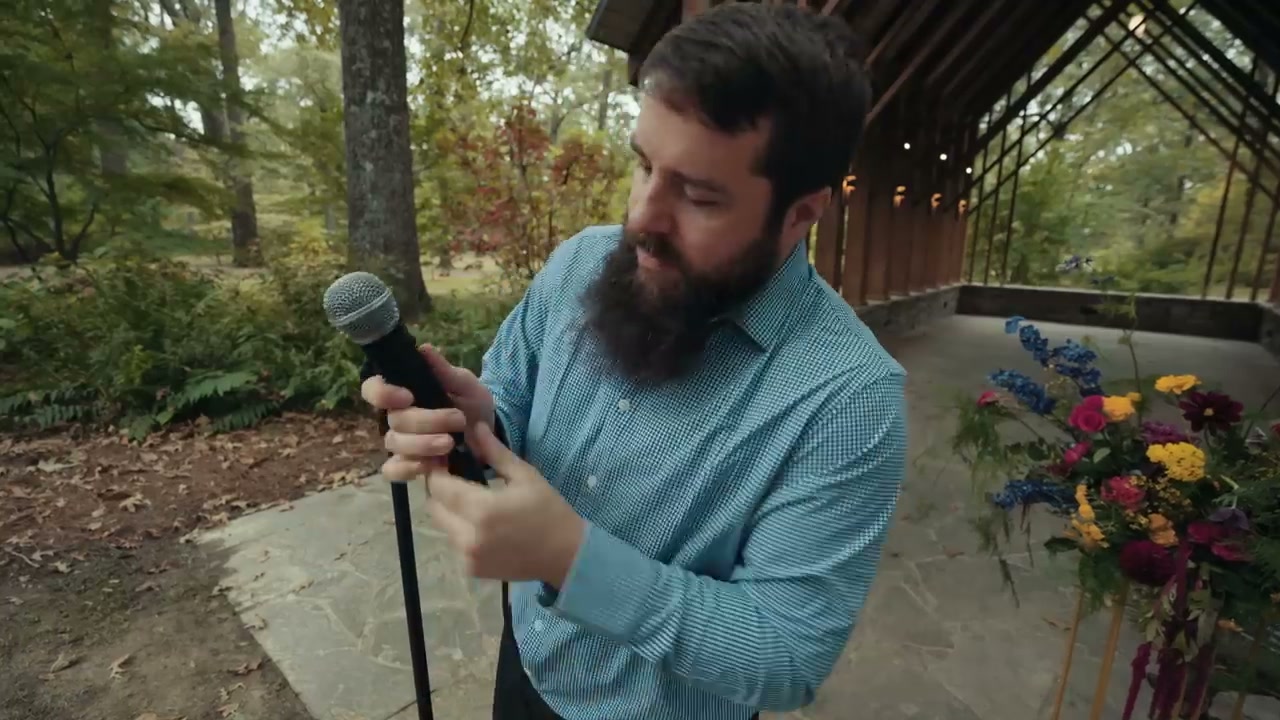 A foam microphone sleeve being slid over a handheld microphone on a stand