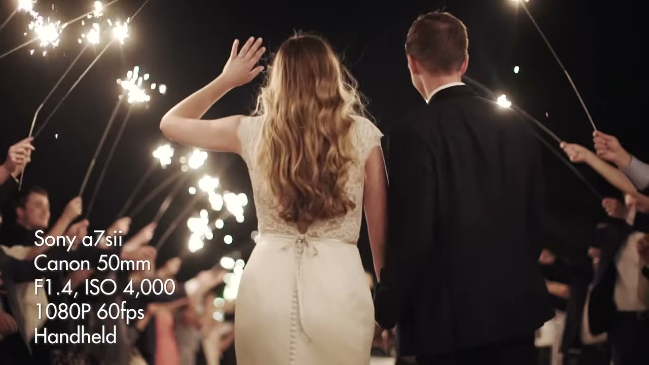 The couple walking through a sparkler exit, overlay reading Sony a7sii, Canon 50mm, F1.4 ISO 4000, 1080P 60fps, Handheld