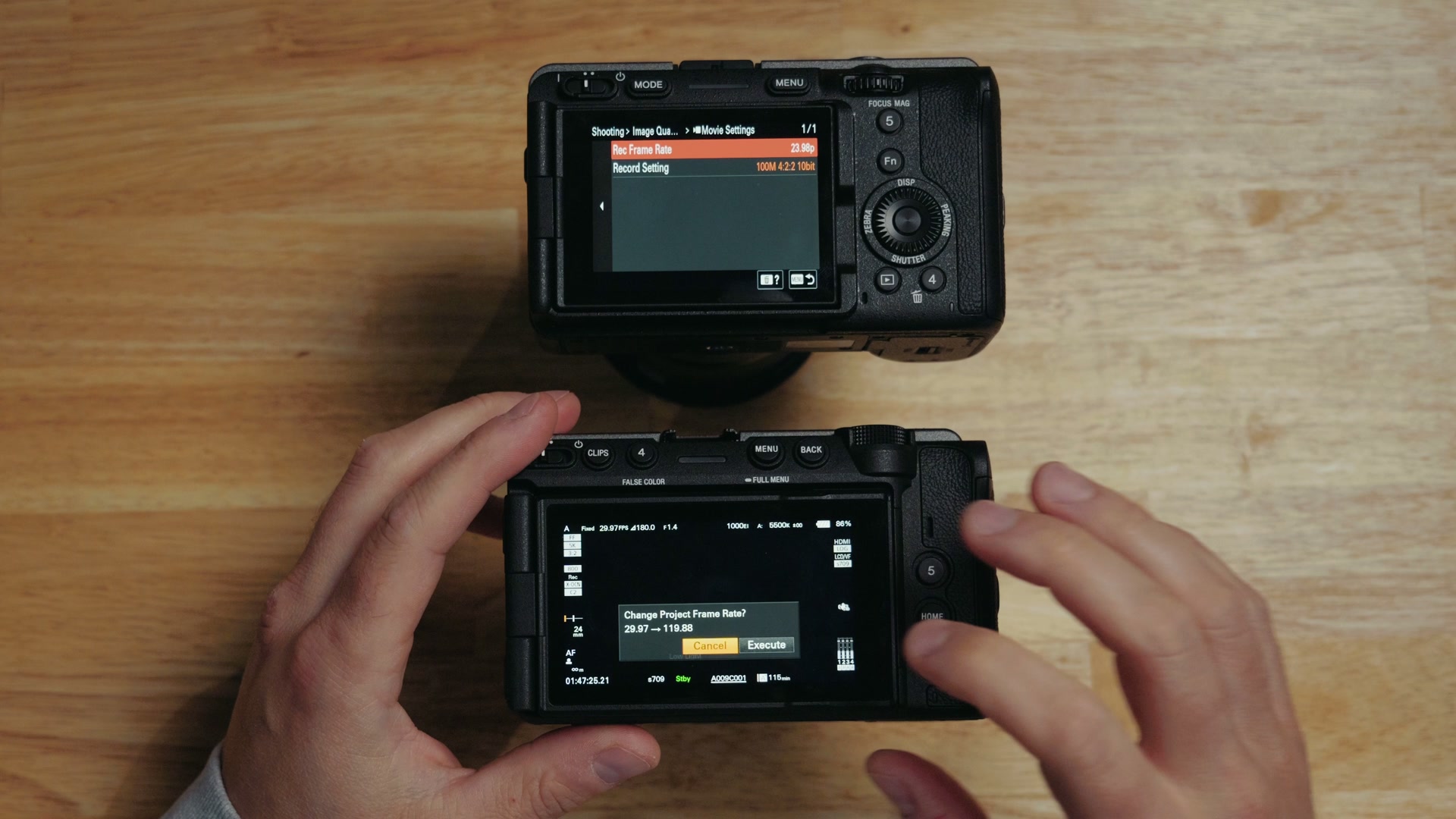 Overhead view of both cameras' rear screens, with the Sony FX5 showing a Change Project Frame Rate confirmation dialog
