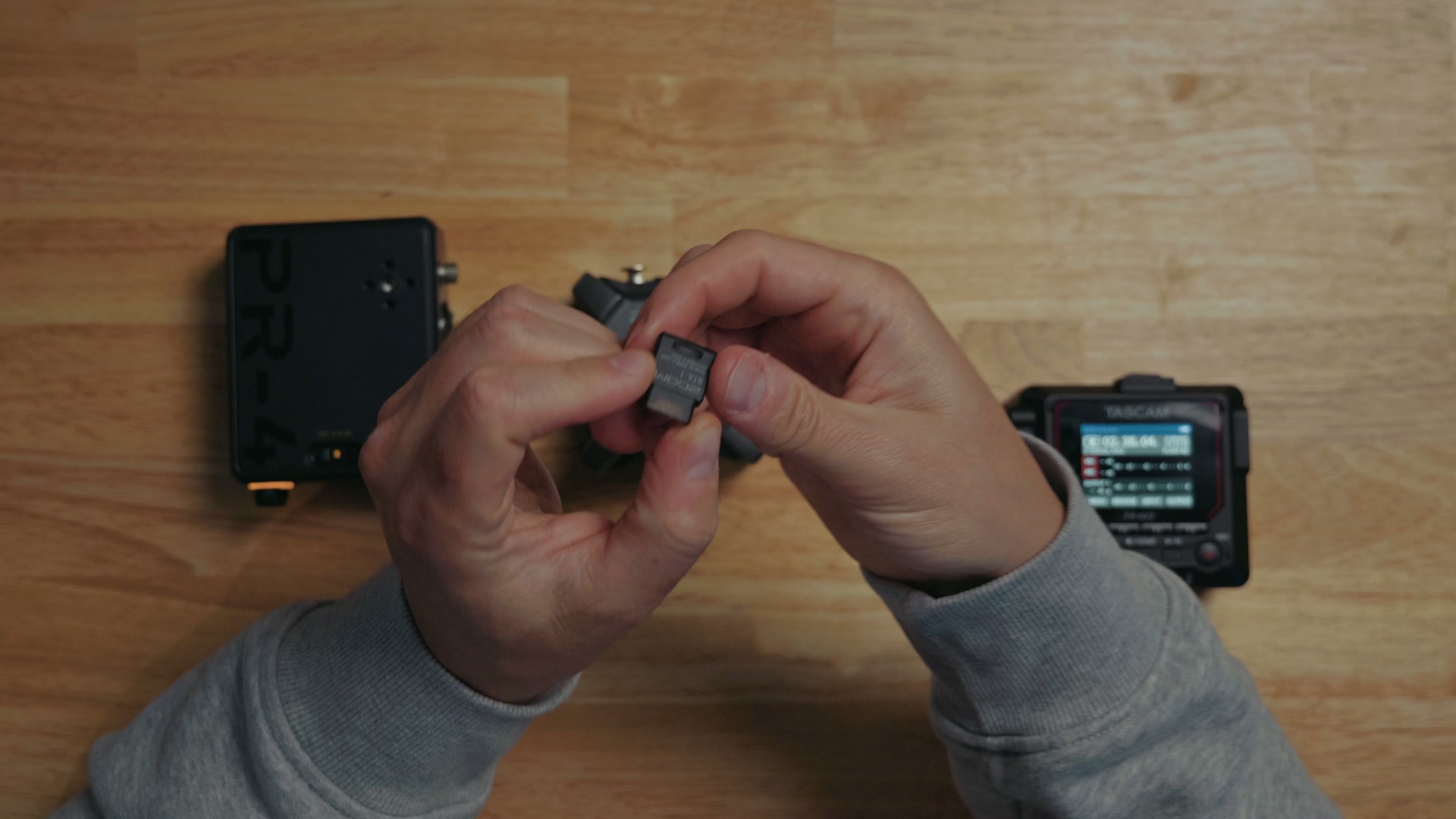 The separate Bluetooth adapter dongle held next to the audio recorder it plugs into