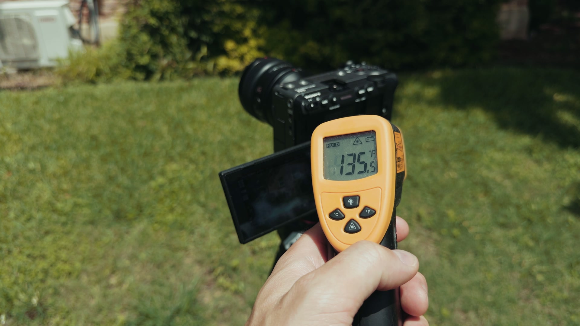 An infrared thermometer reading 135.5 degrees Fahrenheit held in front of the Sony FX5 still recording outdoors