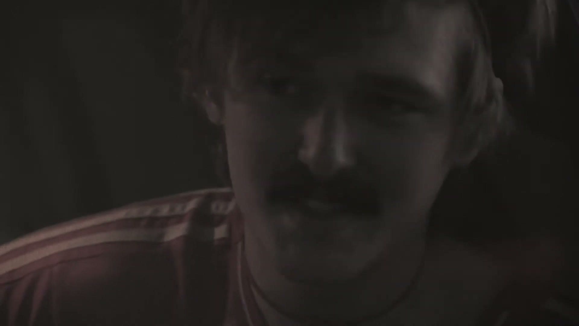 A close, warmly lit portrait of the singer performing at dusk