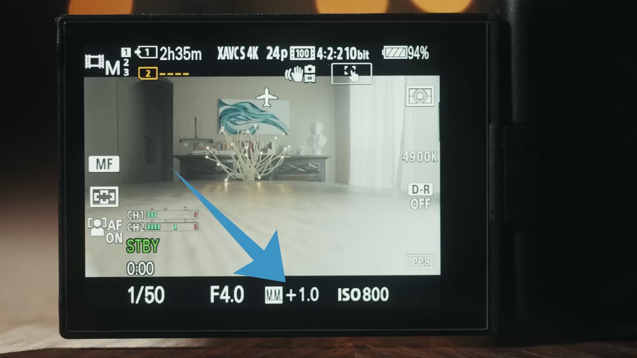 a7S III monitor with a blue arrow pointing to the manual metering readout showing MM +1.0 and ISO 800