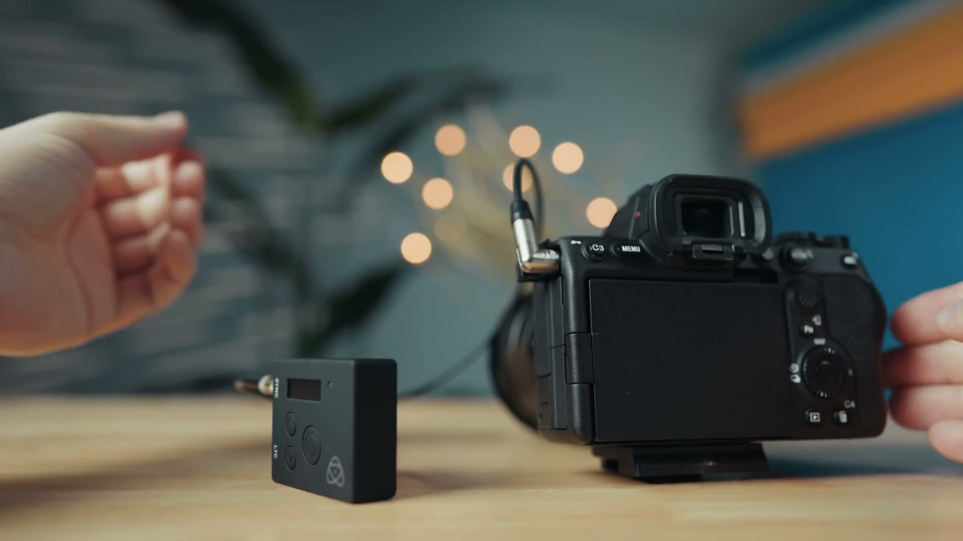 A timecode box next to a Sony camera connected by a cable