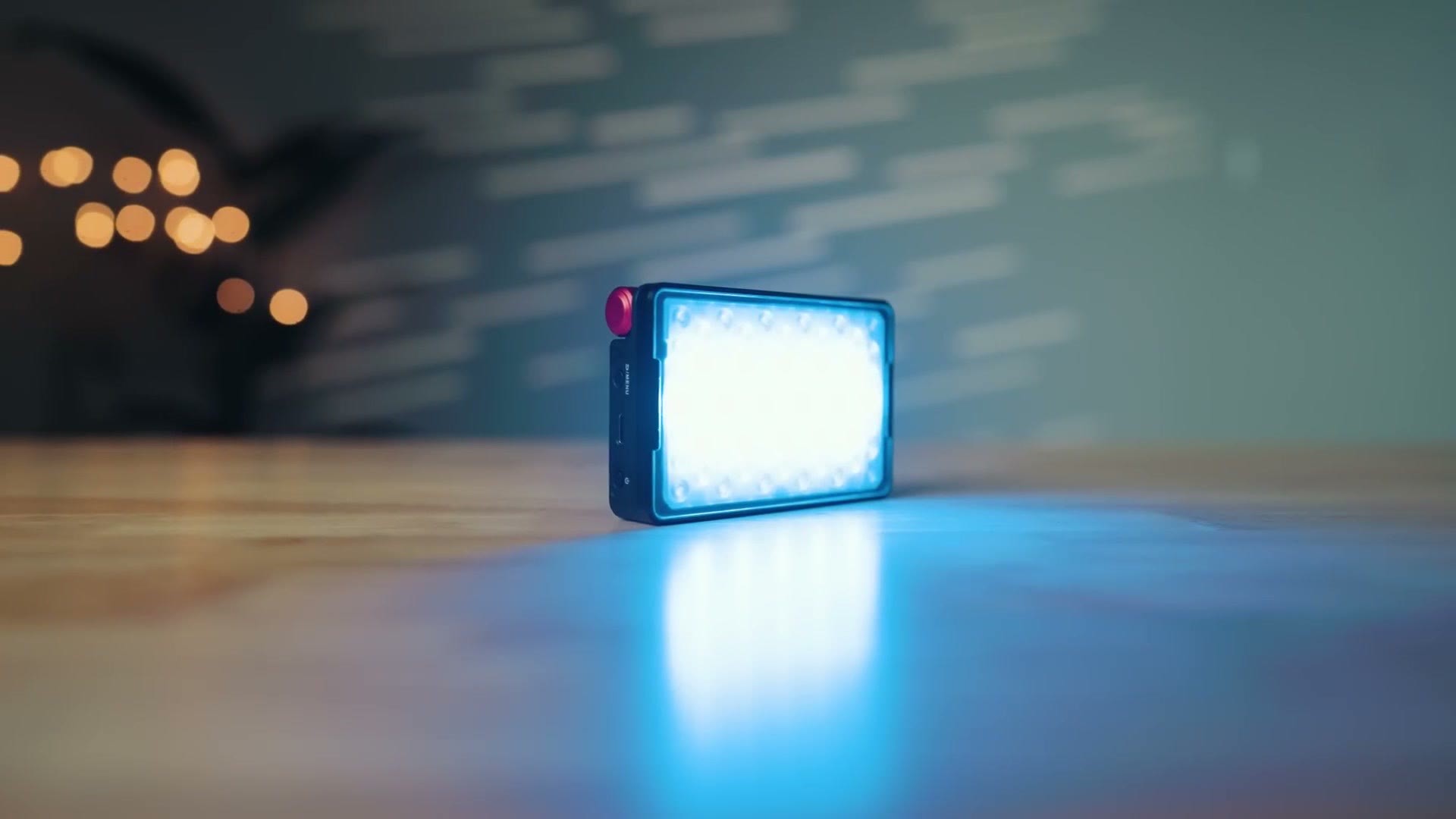 Aputure MC Pro light glowing blue on a wooden table