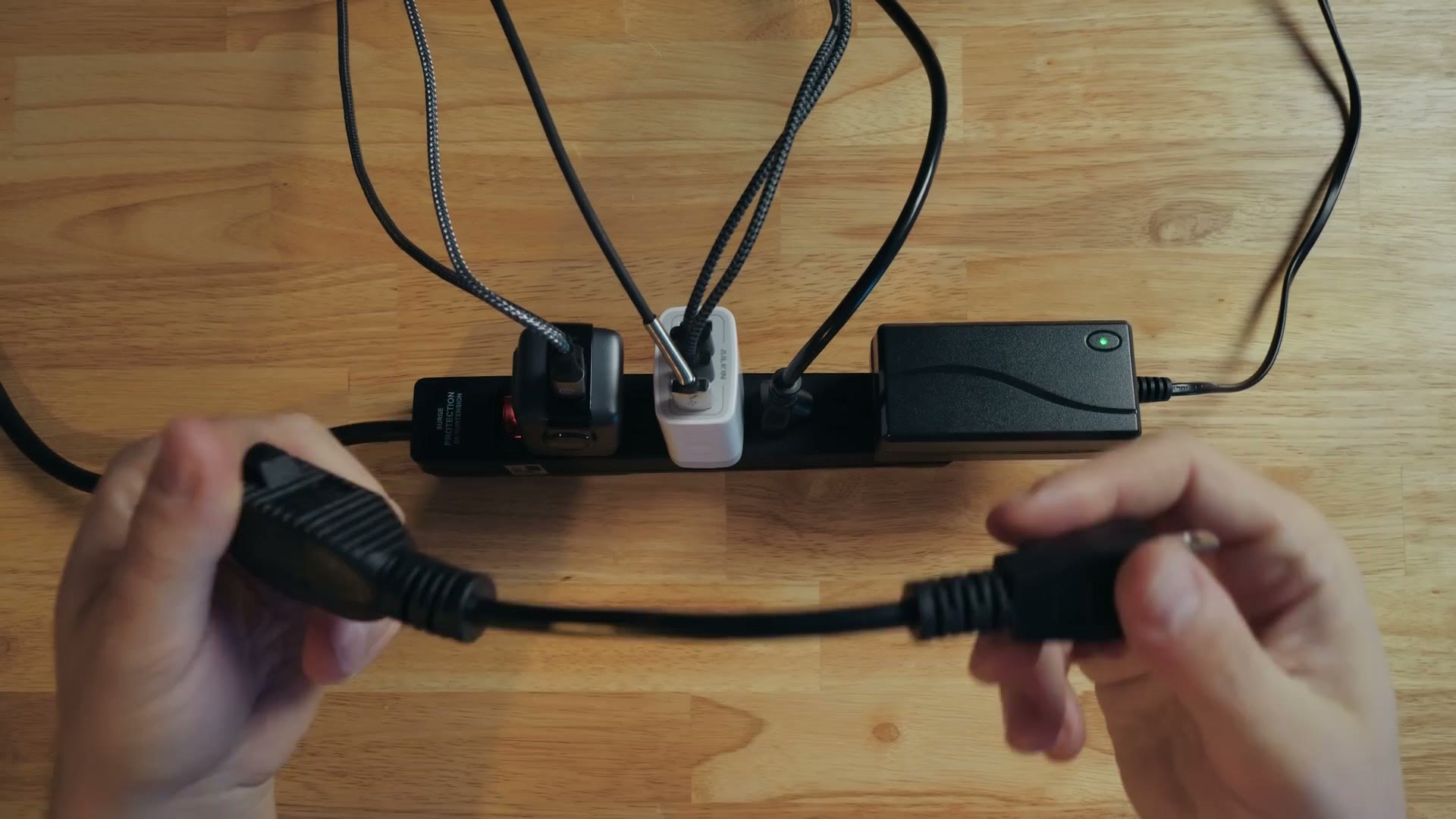 Top down view of a power strip with several oddly shaped power bricks blocking neighbouring sockets