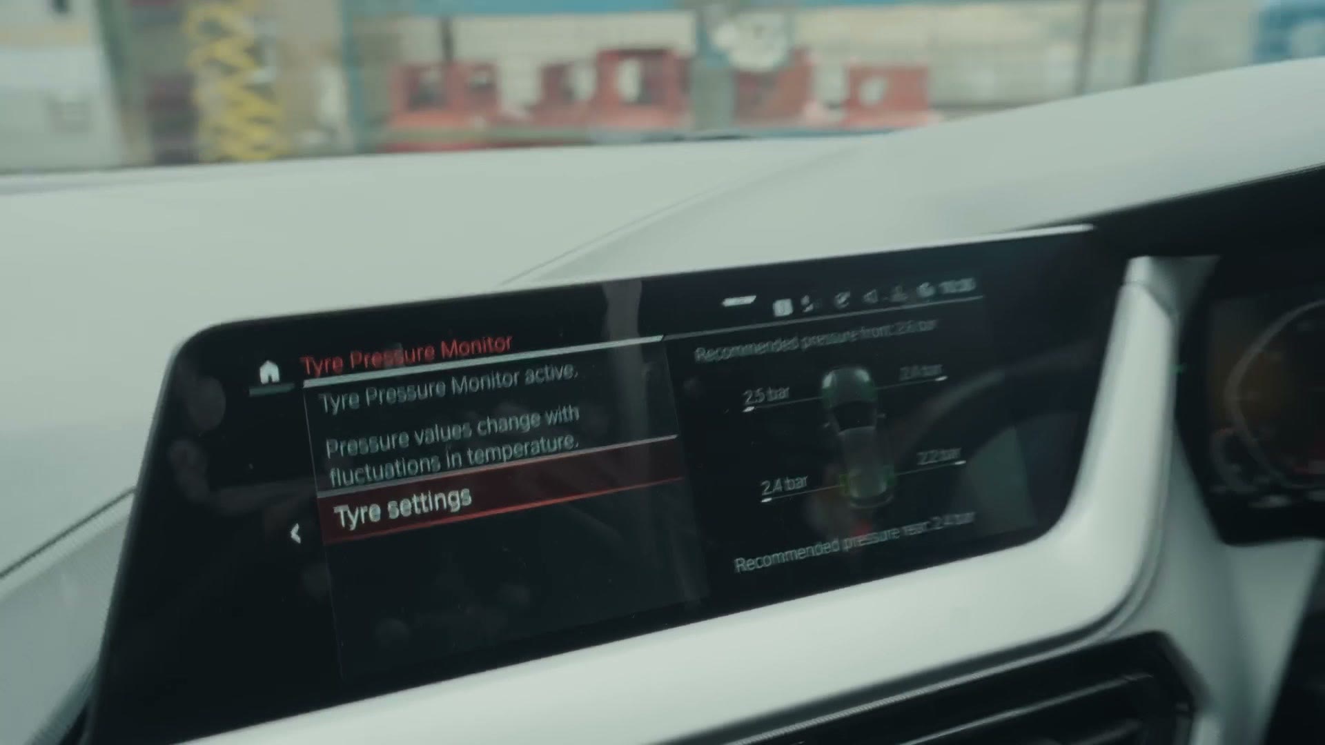 The BMW dashboard display showing the Tyre Pressure Monitor screen with the rear tire back up to 2.4 bar, the recommended pressure