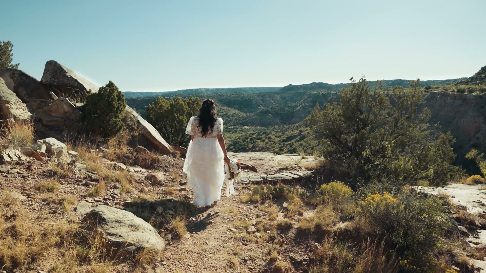 The bride walking through the canyon in her dress