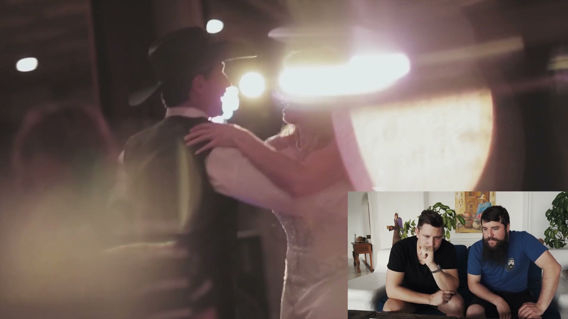 A hazy backlit slow motion shot of a couple dancing at a reception, blown out by a light behind them.