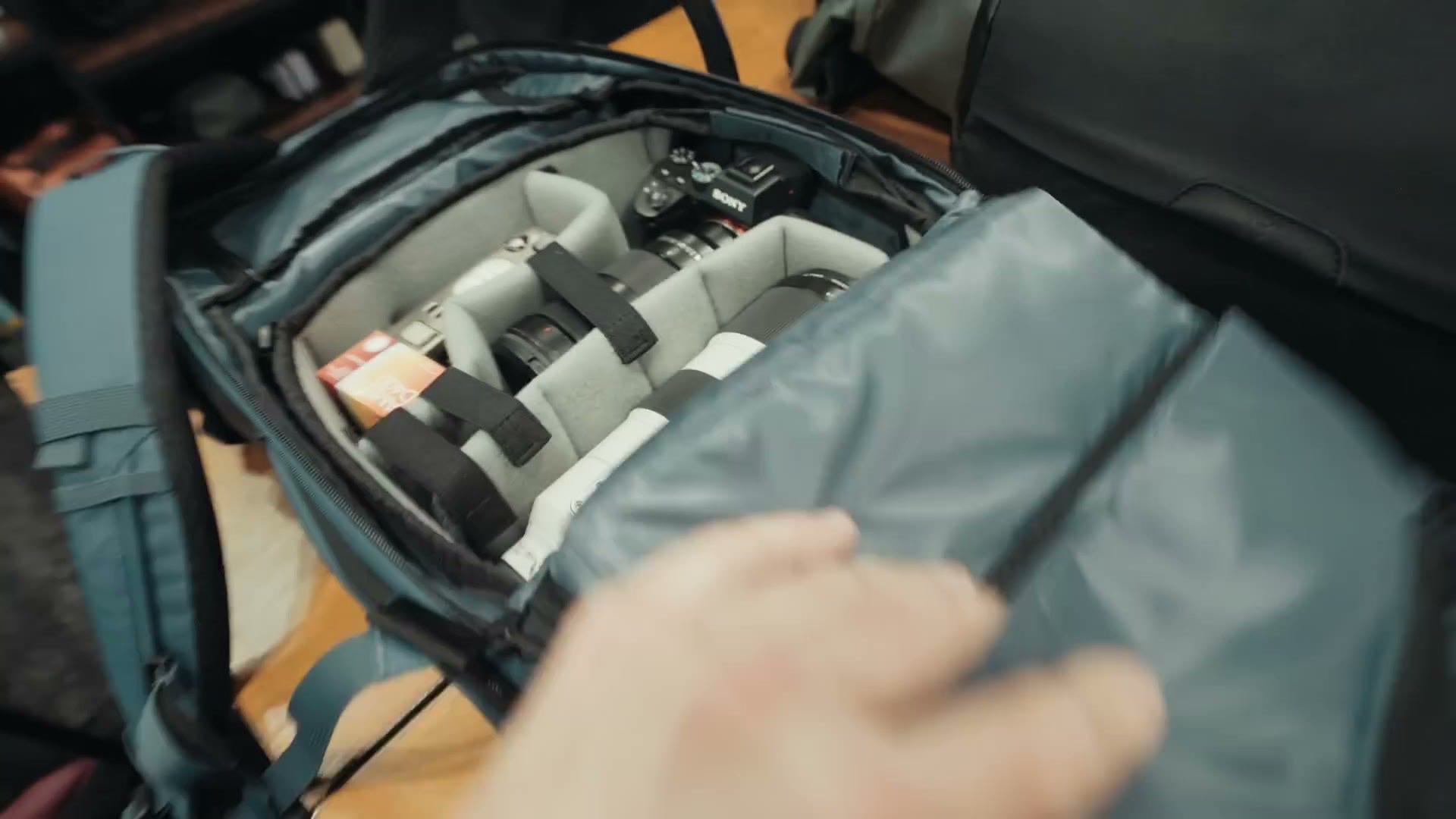 An open Wandrd camera bag showing padded dividers and a camera body packed inside