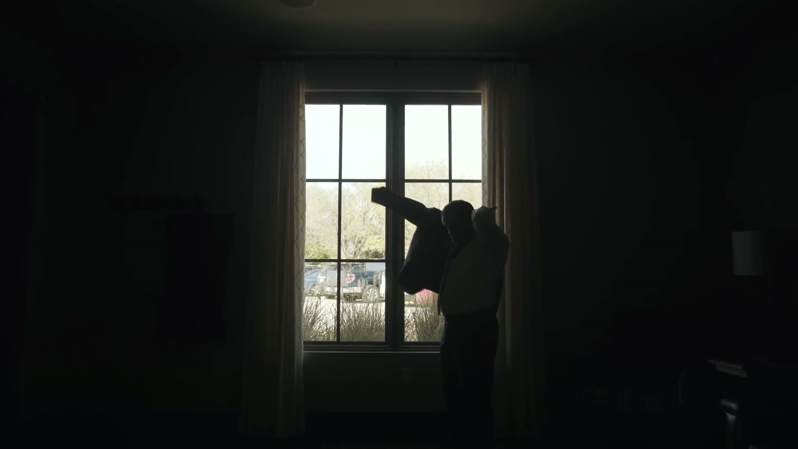 Silhouette of the couple embracing in front of a bright window
