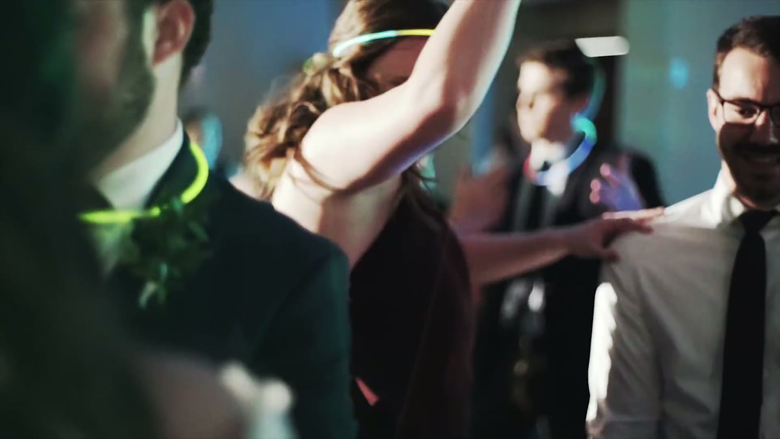 Guests dancing under coloured lights wearing glow sticks