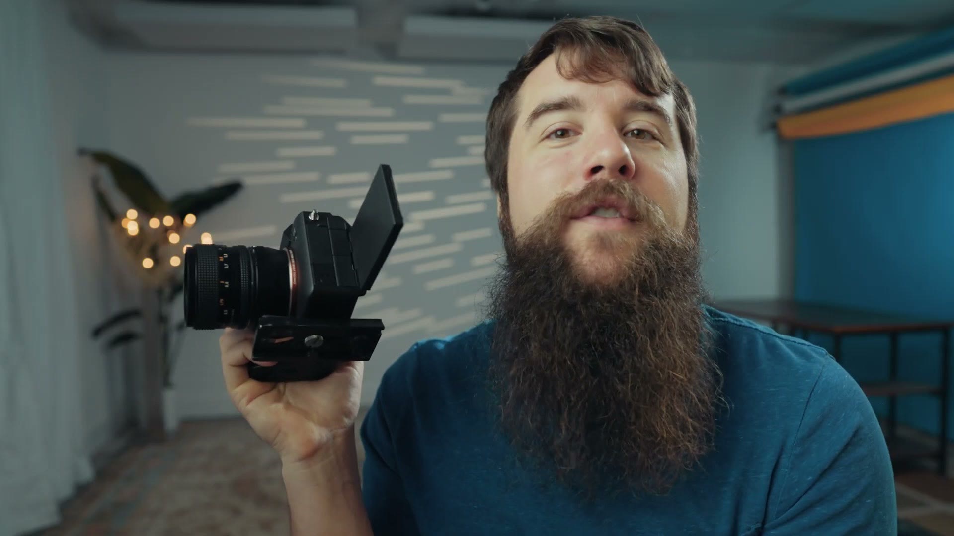 Matt holding a Sony camera with the screen pulled out and card door open
