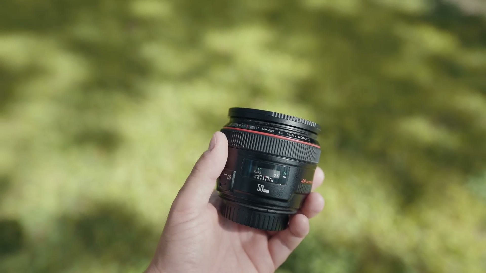 The Canon EF 50mm f/1.2 lens held up to camera