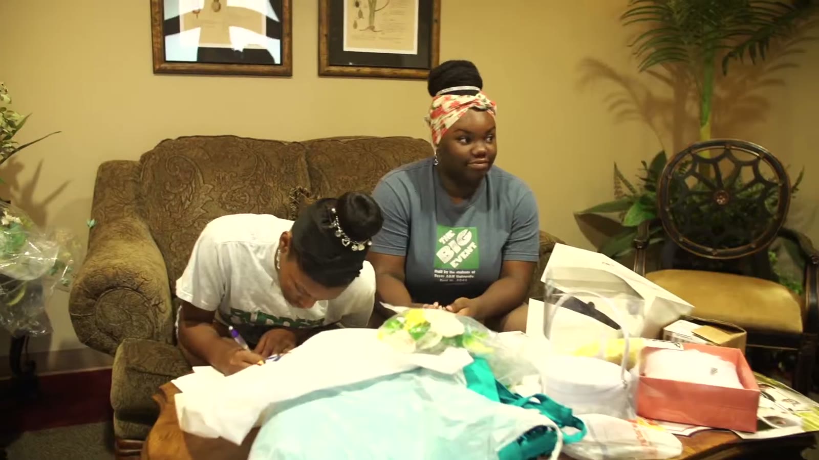 Two women sorting wedding gifts and decorations on a couch backstage before the ceremony