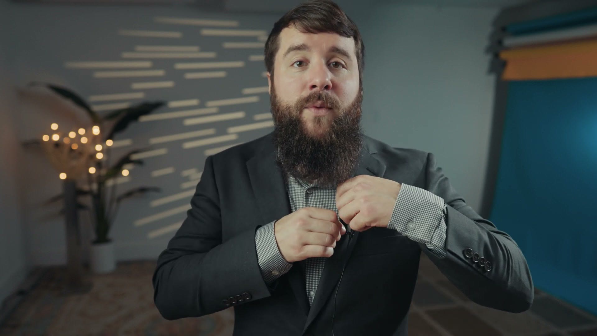Matt clipping a lavalier microphone to the lapel of a suit jacket