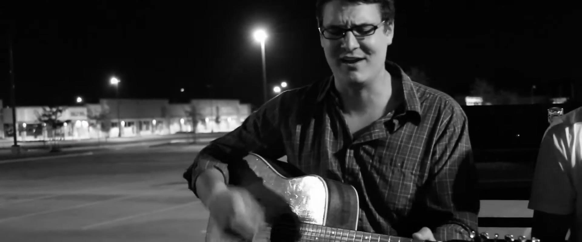 Closer black and white shot of Curt Vernon mid-lyric, streetlight glare reflecting off the guitar's body