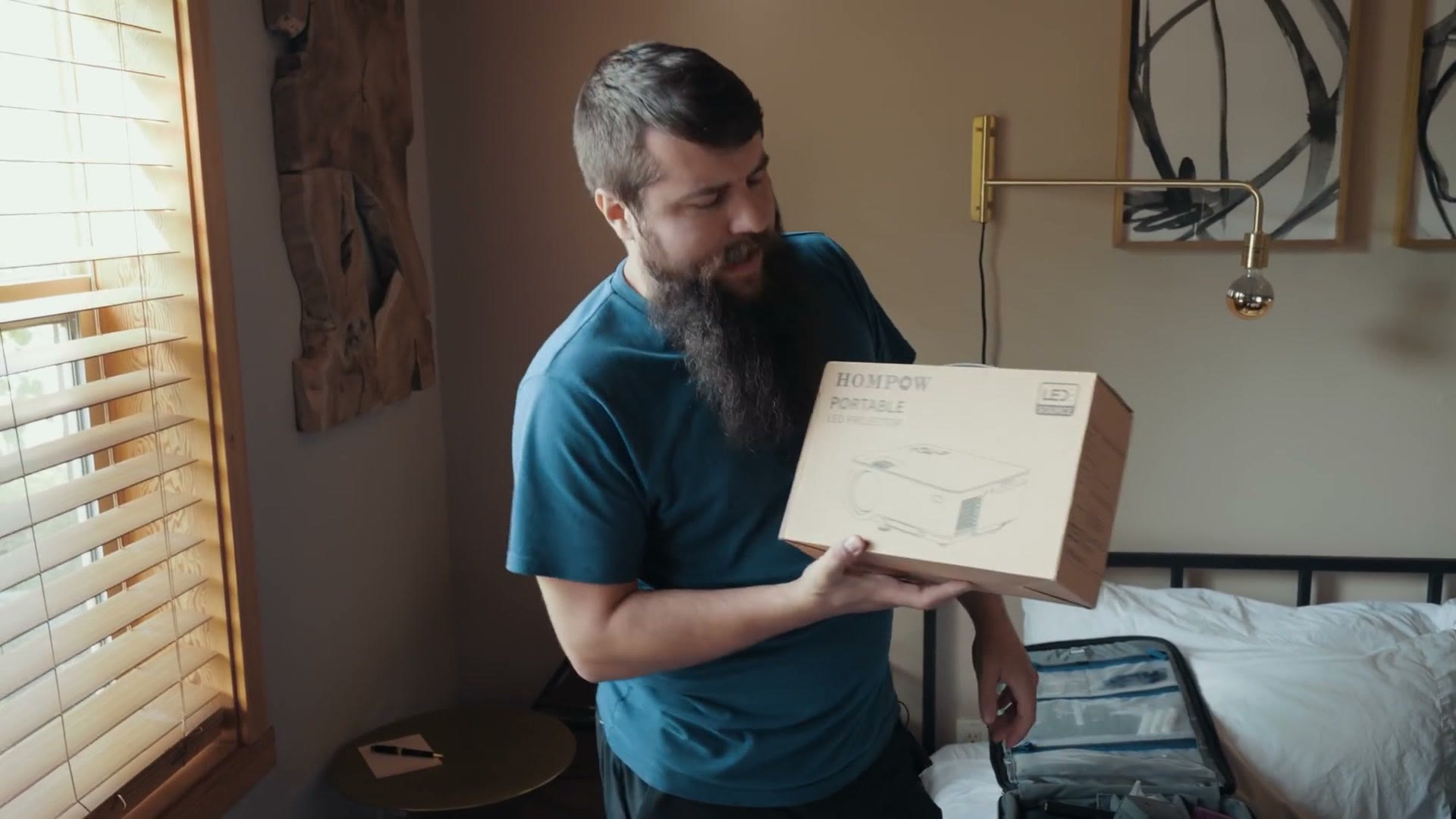 Matt holding a cardboard box for a Hompow portable LED projector.