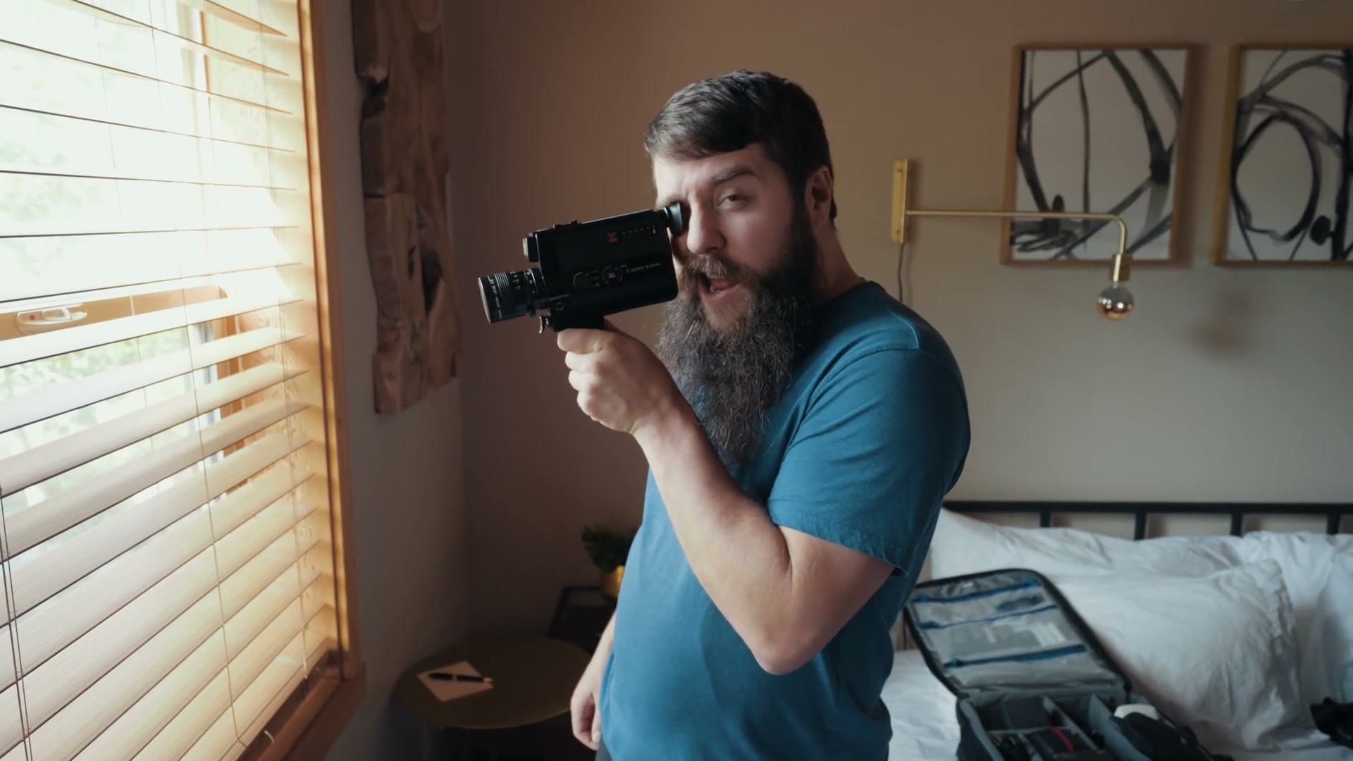 Matt holding a vintage Super 8 film camera up to his eye.