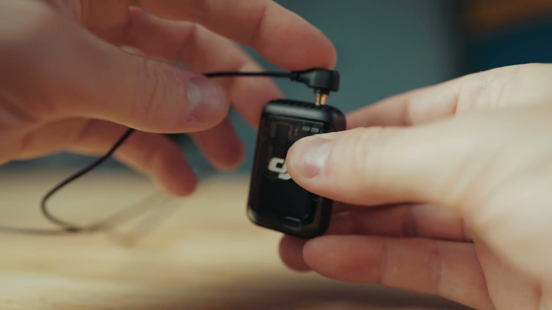 DJI Mic 2 transmitter with the lav cable looped under the clip