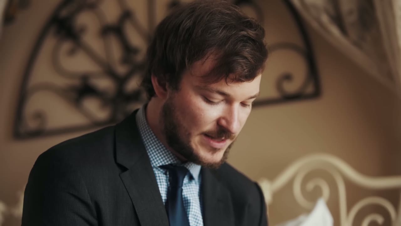 The groom looking down and smiling during the getting ready portion of the day