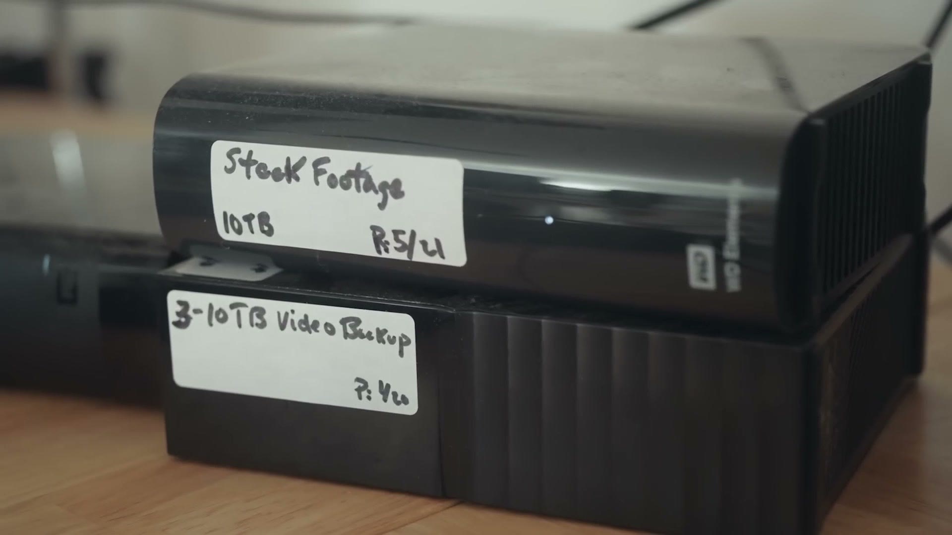 Two external hard drives labeled Stock Footage 10TB and 3-10TB Video Backup