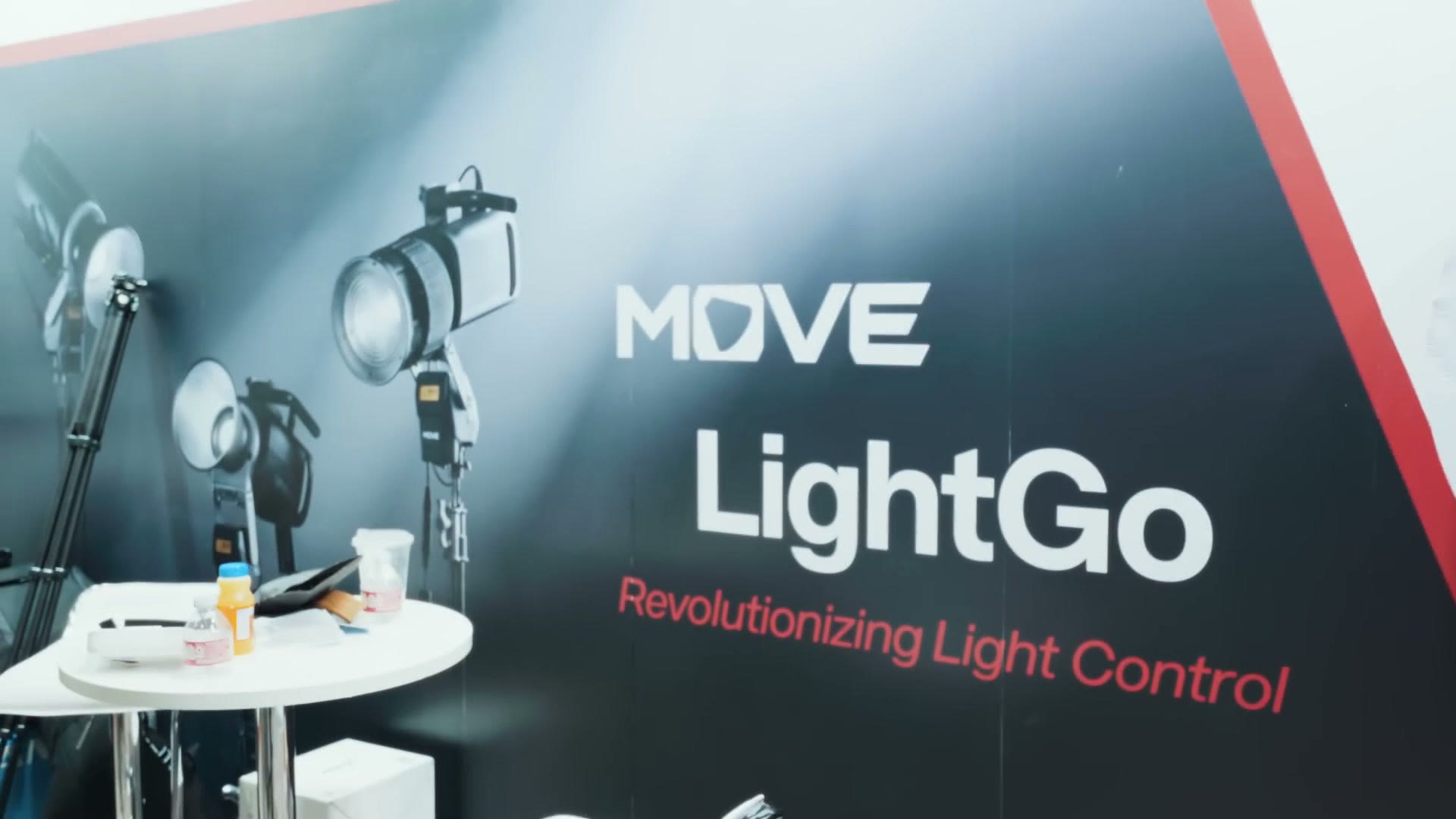The Falcam booth banner reading MOVE LightGo, Revolutionizing Light Control, with lights mounted on stands in front of it