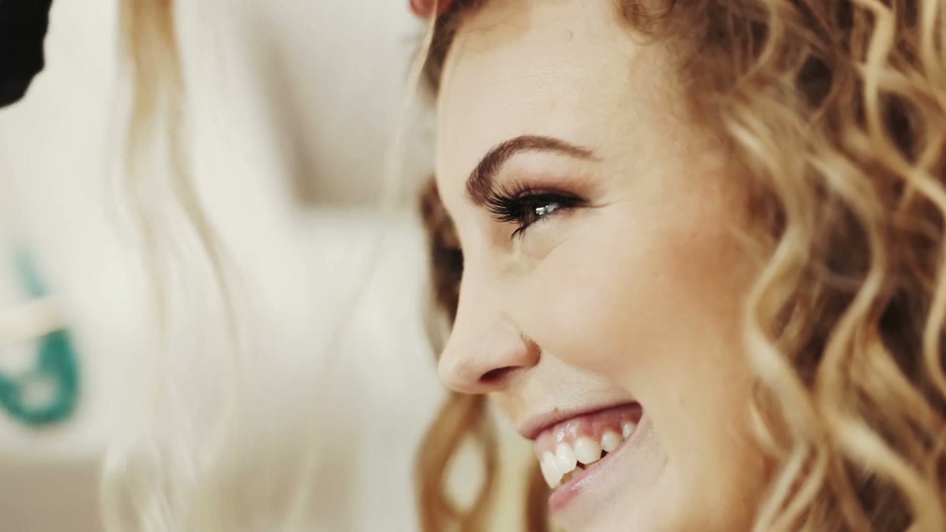 An extreme close up of a bride laughing, her eyelashes sharp and everything behind her falling away