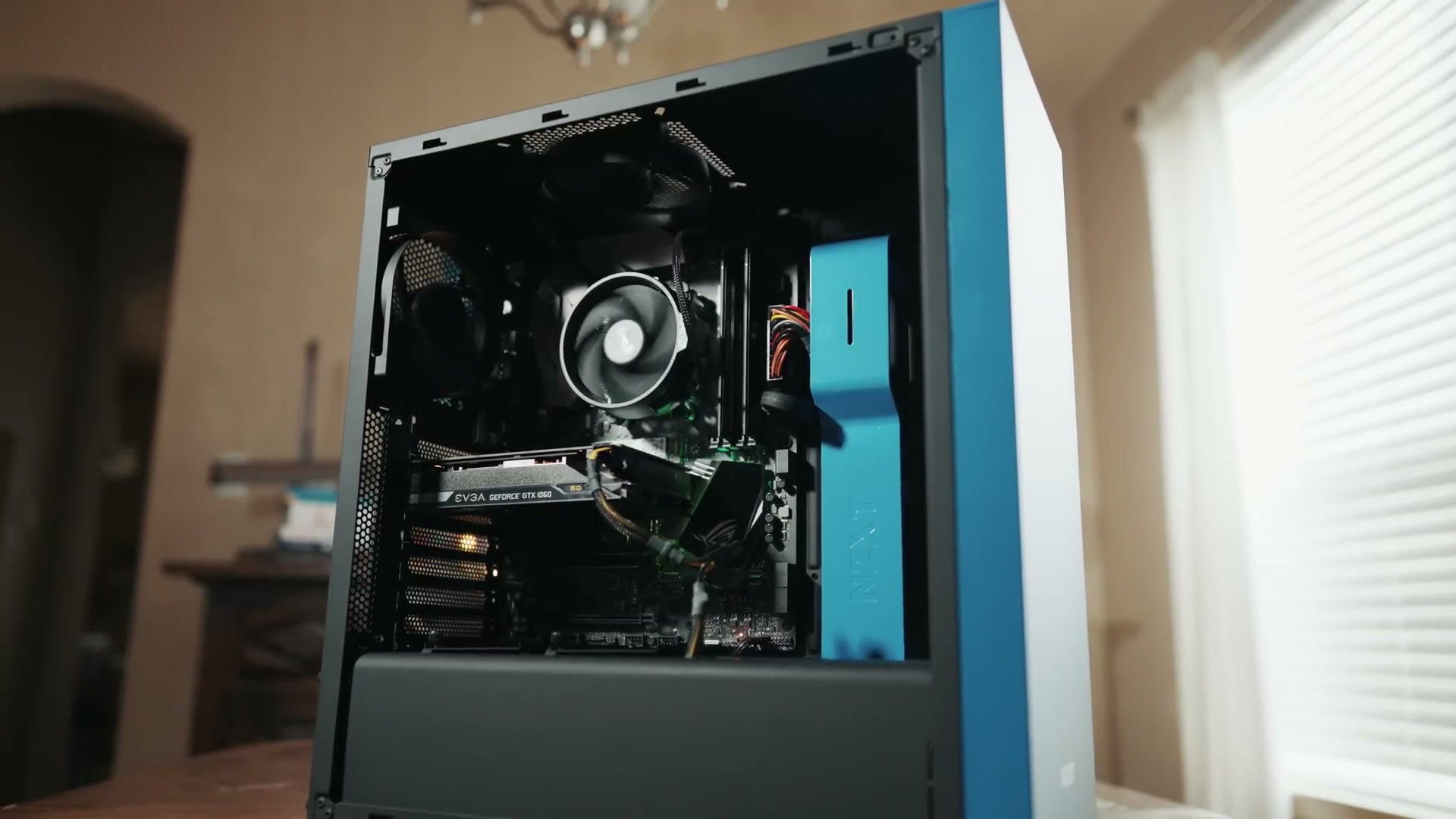 Finished build with the tempered glass side panel open, showing the CPU cooler and GPU, on a table by a window