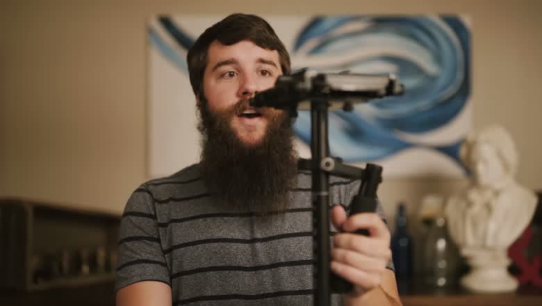 Holding a Glidecam HD-4000 with a camera mounted on top, the counterweight sled below