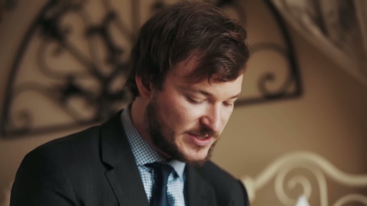 The groom in a dark suit and checked shirt before the ceremony