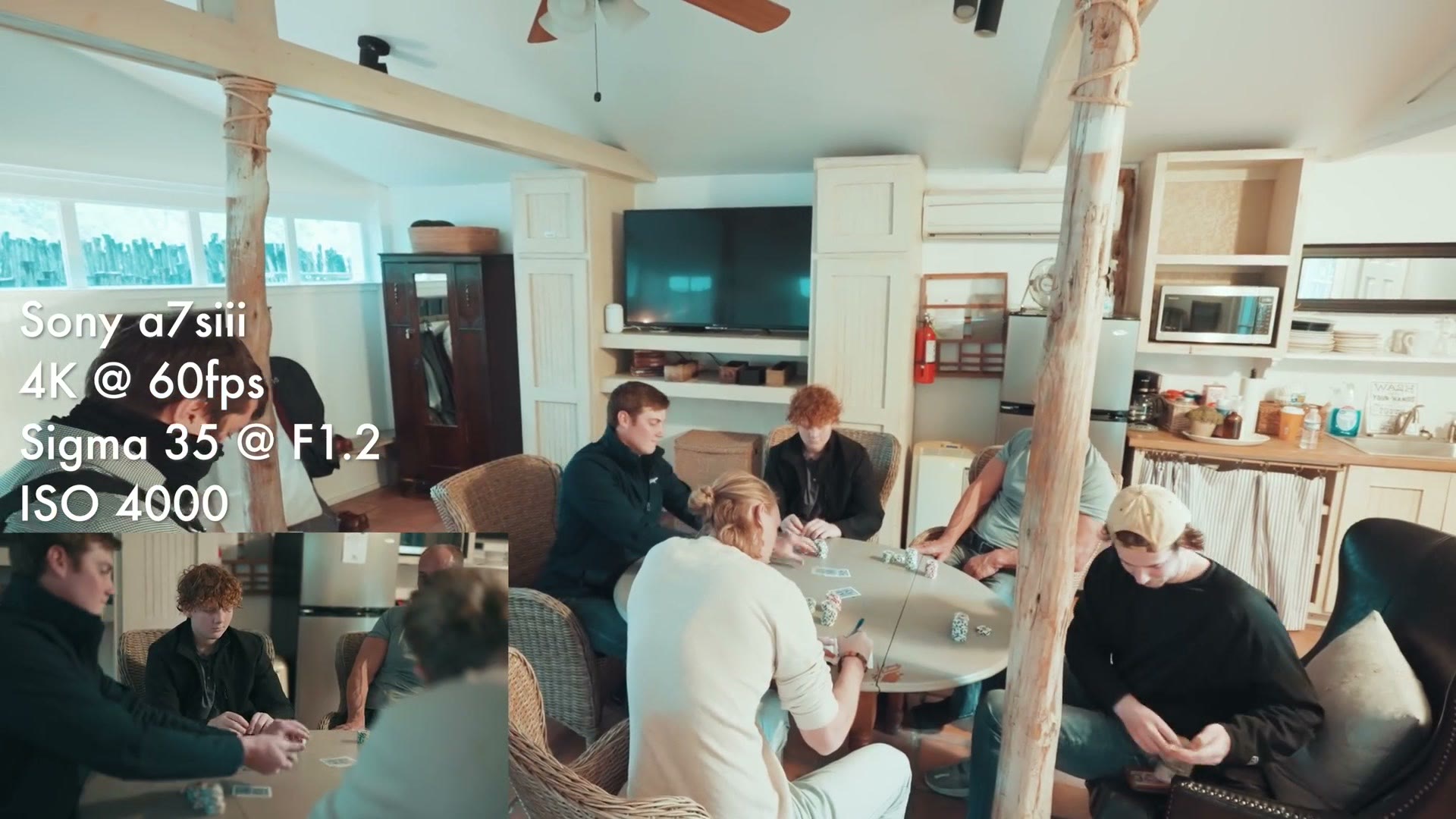 Groomsmen gathered around a table playing cards in a cabin living room ahead of the wedding