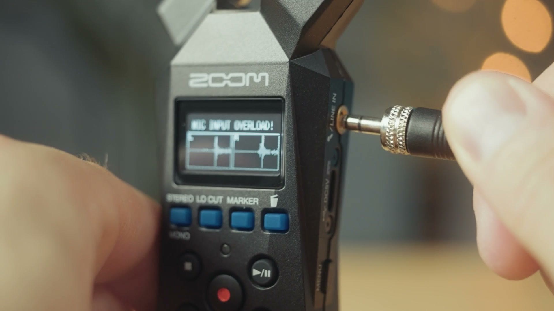 A microphone cable being plugged into the Zoom H1essential