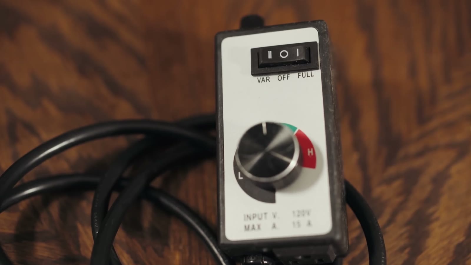 Close-up of a dimmer switch labeled VAR/OFF/FULL with a Low-to-High power dial, on a wood table