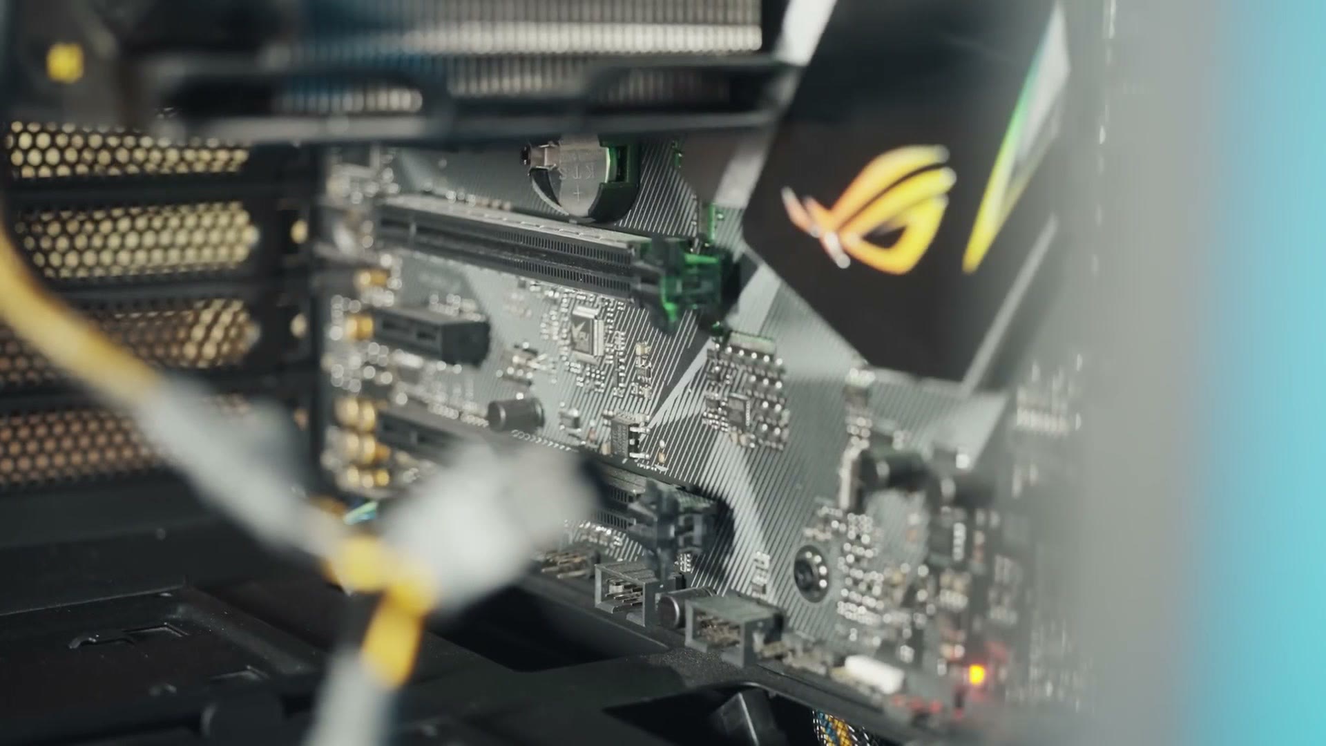 Motherboard being installed in the case with the ROG box and PCIe slots visible in the background