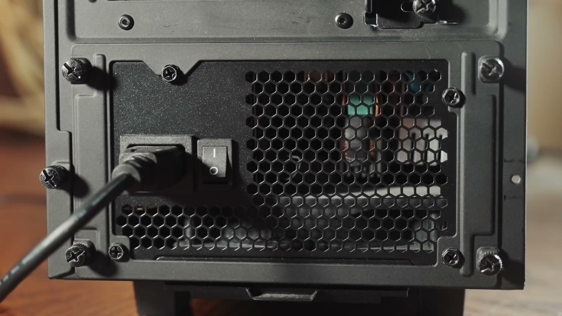 Close-up of the power supply's rear panel with the power cord plugged in and the switch flipped on