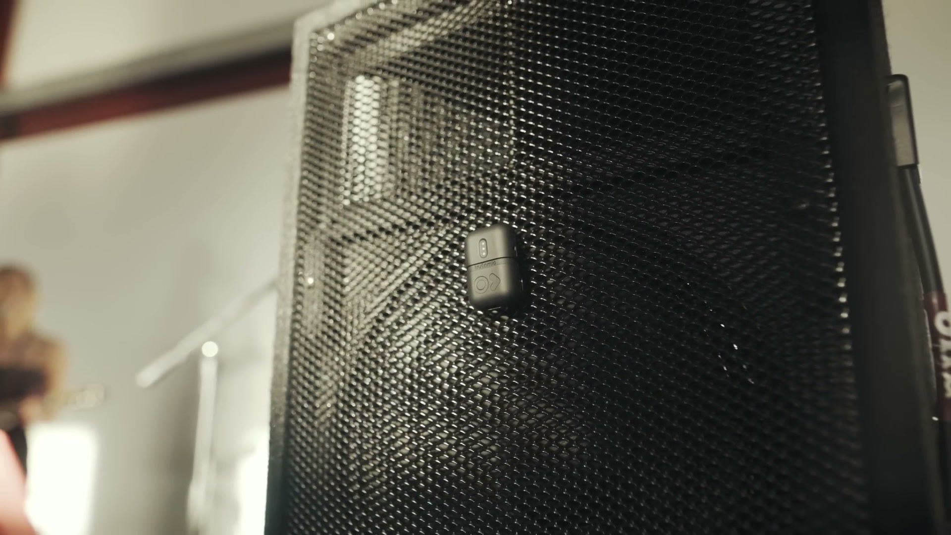 The Instamic magnet mounted to the metal mesh grille on the front of a PA speaker at a wedding reception