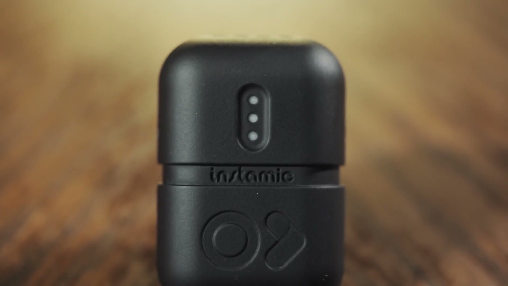 Close up of the Instamic showing its three status lights and the O shaped button below the branding