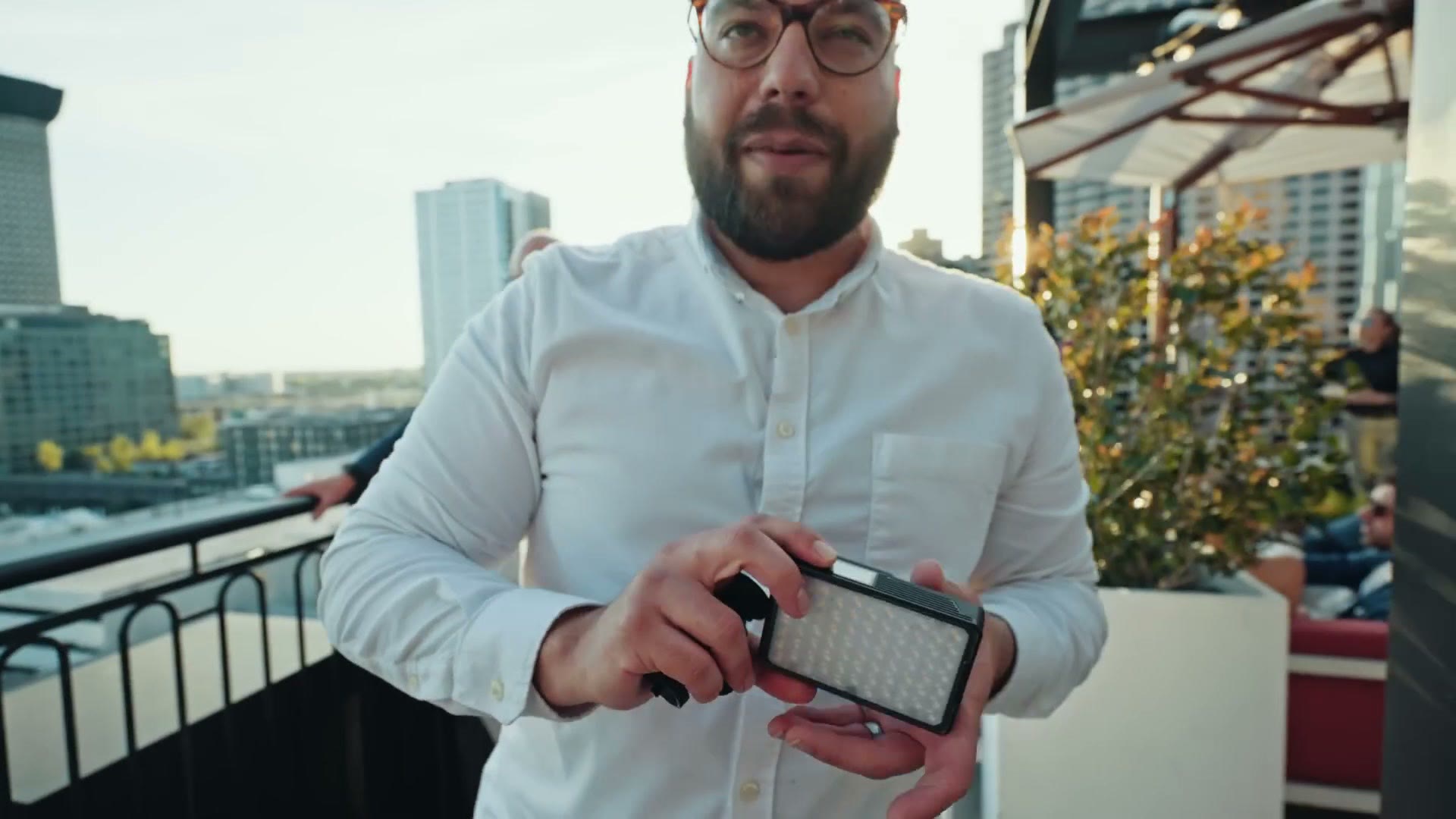 Caleb holding an Aputure MC Pro light with magnets on the back
