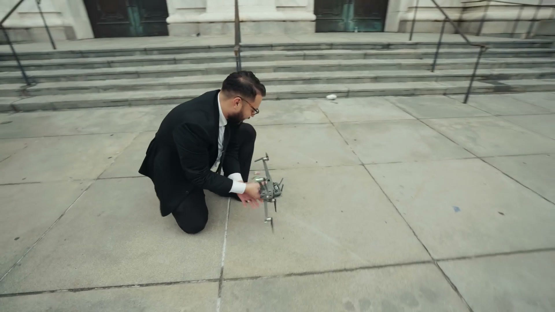 Caleb kneeling in a New Orleans street launching a drone