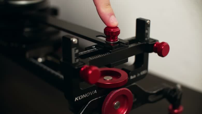 Close-up of the assembled Konova Master Pan showing the red locking knobs, the adjustment scale and the Konova branding