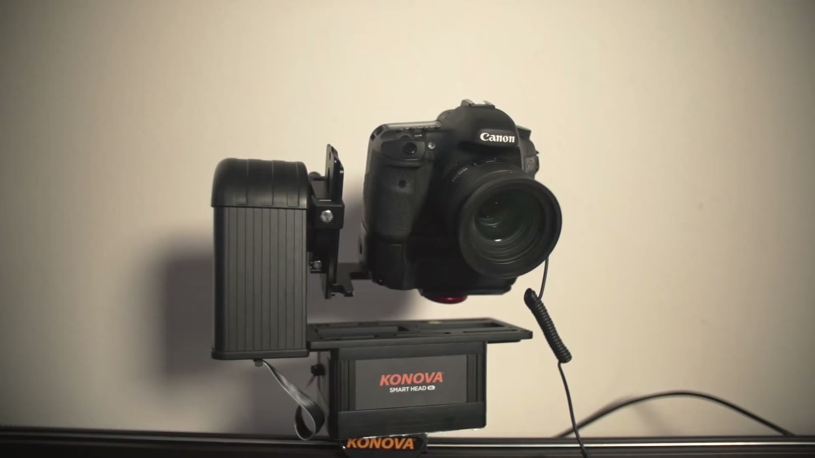 Canon DSLR mounted on the Konova Smart Head unit, sitting on its slider rail against a plain wall