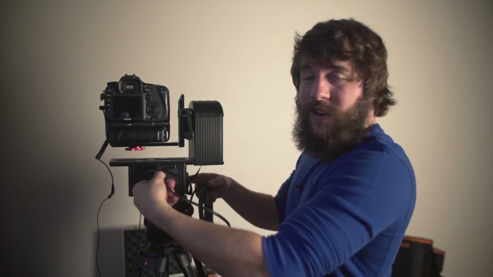 Bearded man in a blue shirt adjusting the Smart Head controls with the camera attached above it