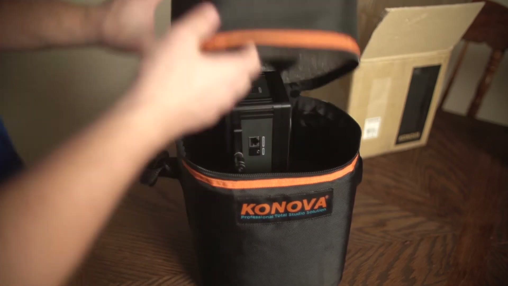 A padded Konova branded case open on a table with the Smart Head seated in a foam cutout inside it