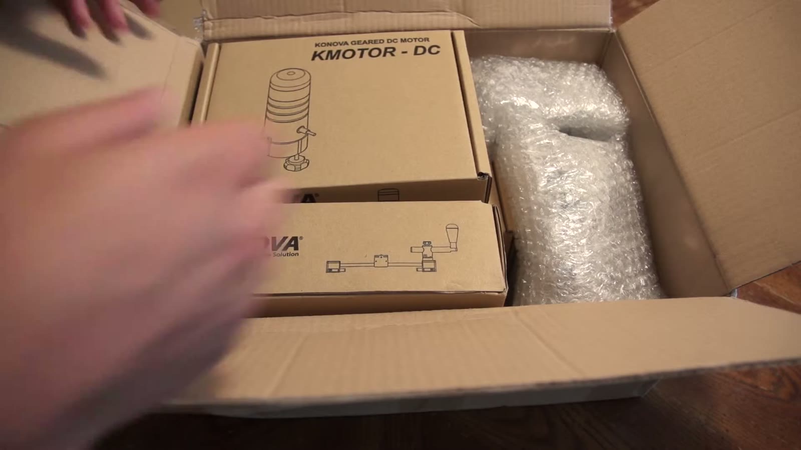 Konova KMOTOR-DC box being lifted out of the shipping carton
