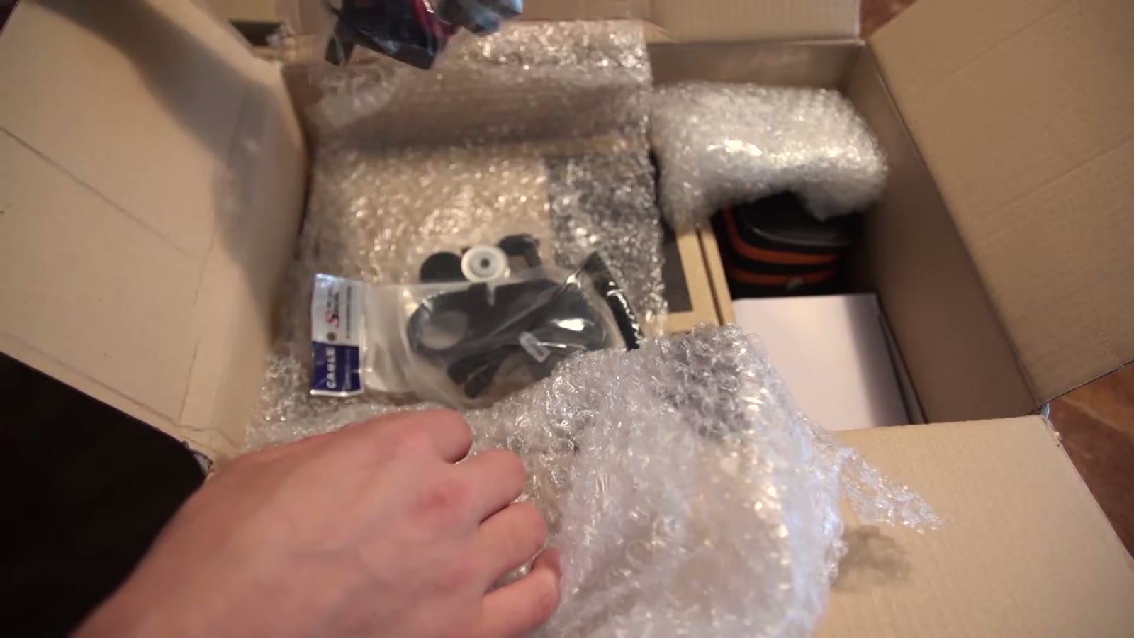 Bag of stoppers, adapters and mounting hardware sitting in the carton