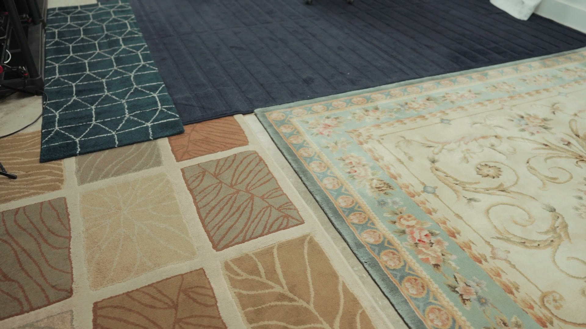 Overlapping rugs covering the concrete studio floor