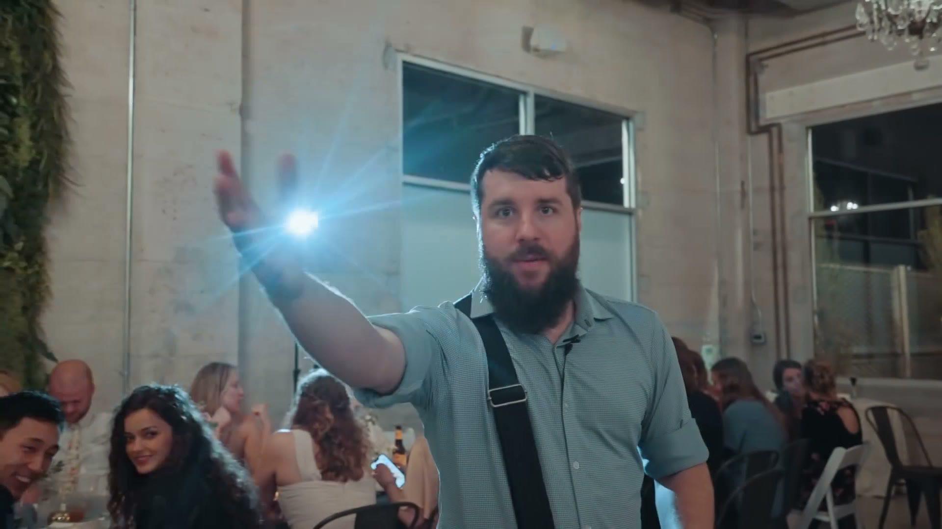 Matt holding a small light up above seated guests during toasts